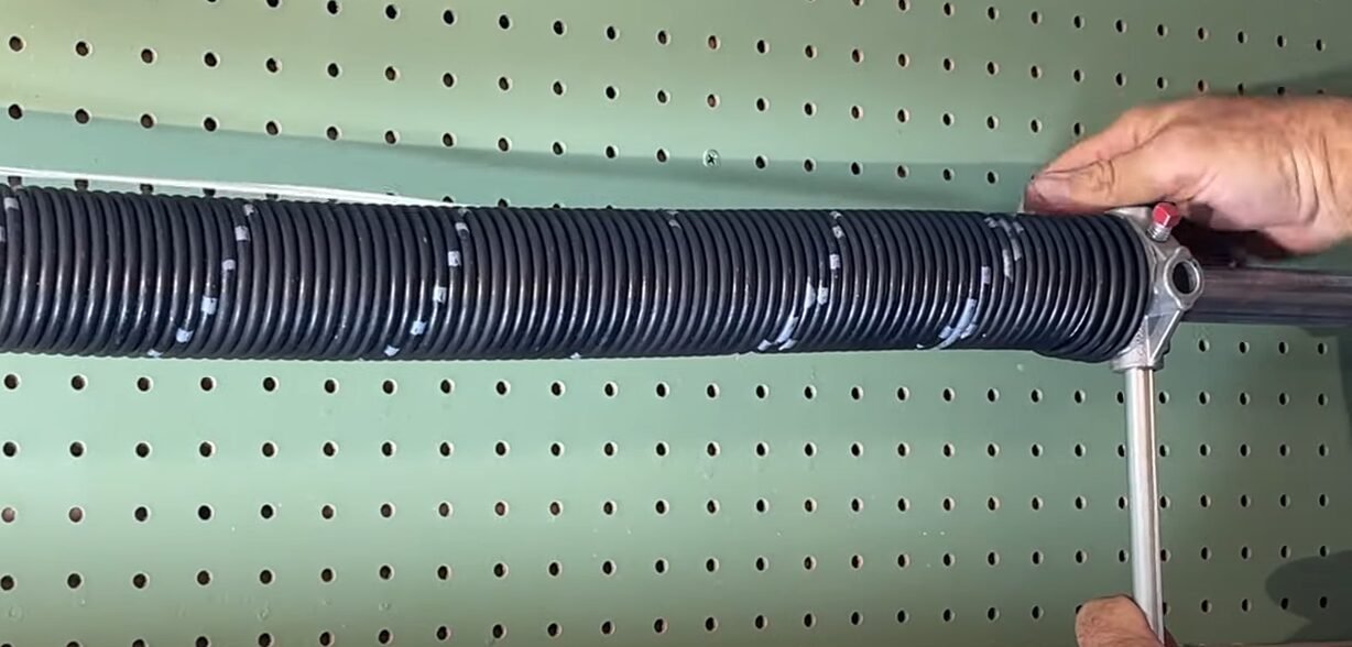 Technician performing garage spring door repair on a residential garage door at Local Garage Door Repair Company